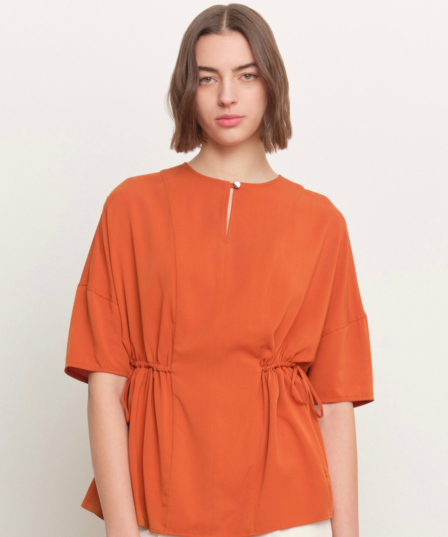 The model is 181 cm tall and is wearing a size 2 in ORANGE.